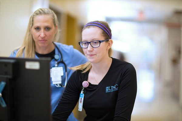Jan Burge, RN, and Lisa Ecklund, RN, work together to coordinate patient care. (Photo by Brian Strickland)